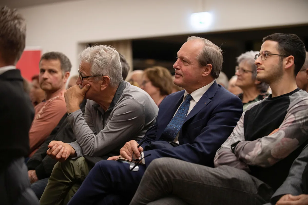 Ein Mann lauscht sitzend einem Vortrag.